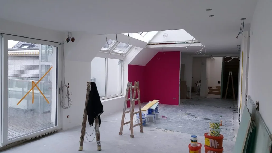 Dachgeschoss-Wohnung mit magenta Akzentwand und Velux-Dachfenstern