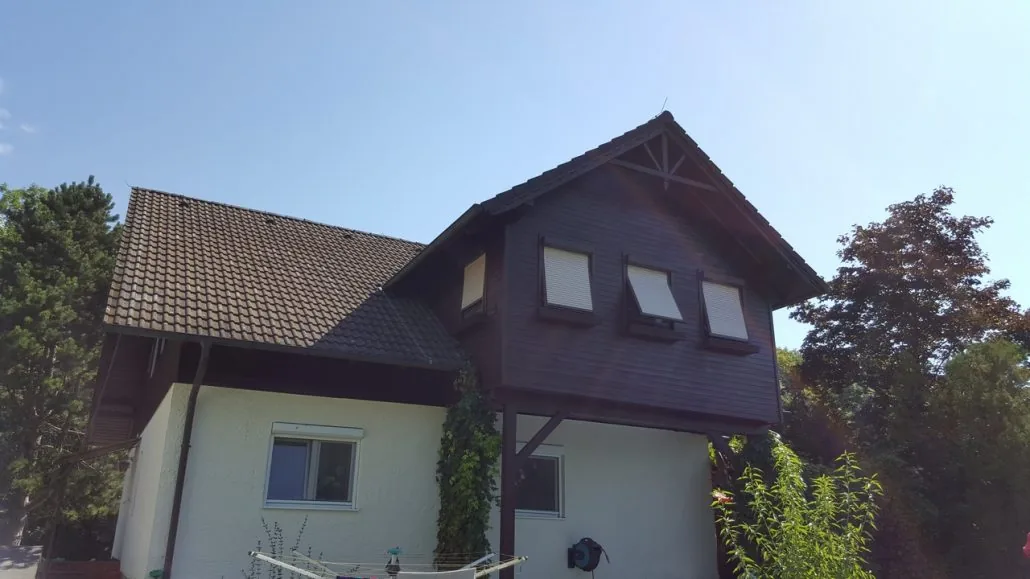 Einfamilienhaus mit Putzfassade und braunem Holzgiebel gestrichen