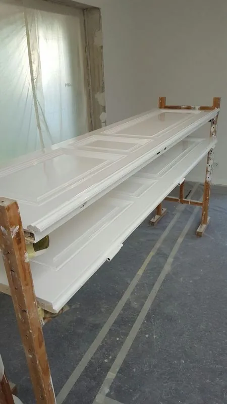 Türblätter weiß lackiert auf Holzböcken — Werkstattaufnahme